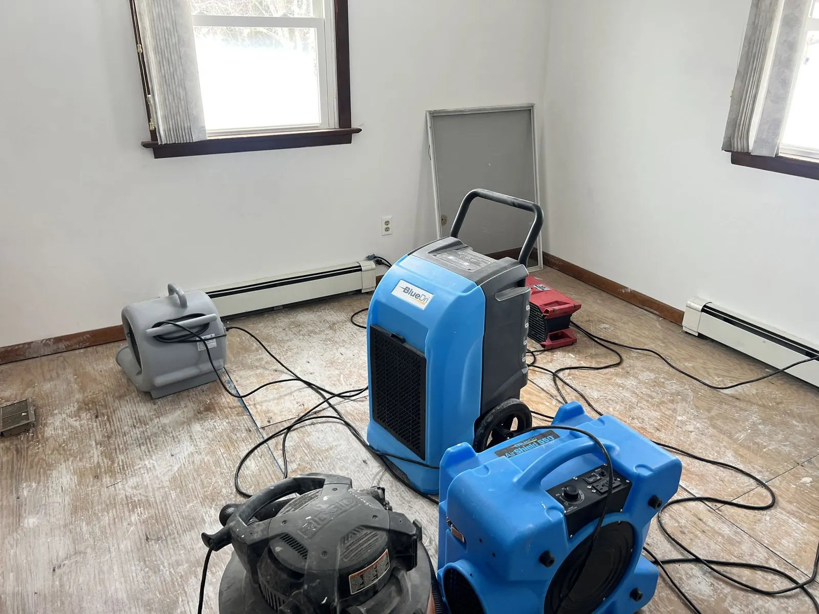 DryMaster dehumidifier and air movers drying a bedroom floor